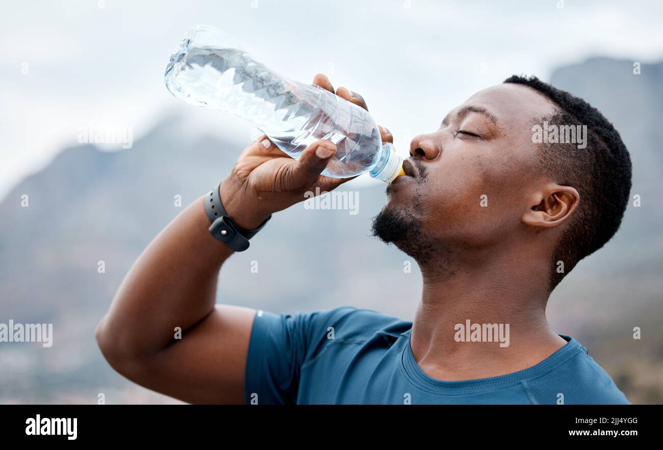 You worked hard and did well today. a sporty young man drinking water while exercising outdoors. Stock Photo