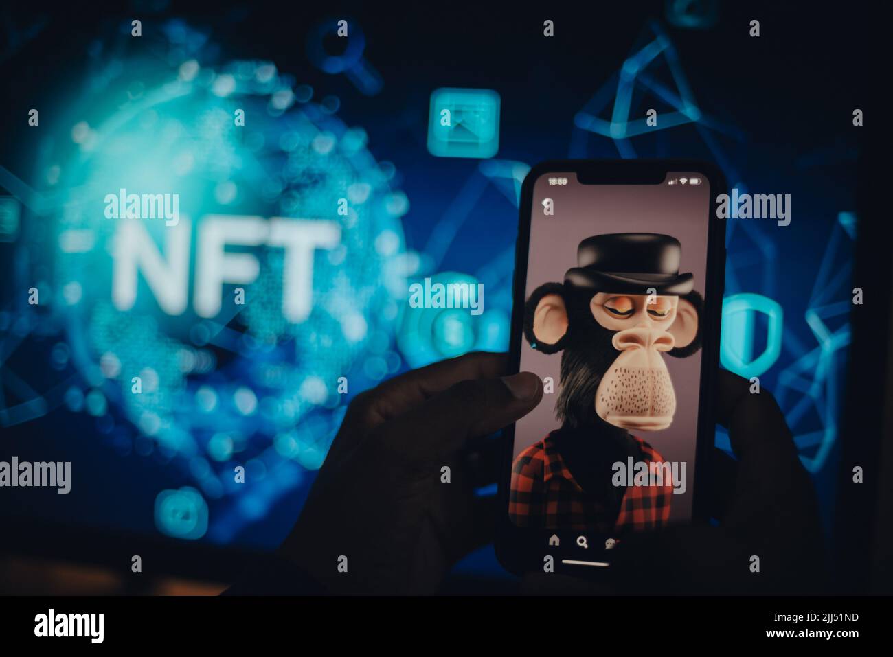 Hand holding a mobile phone showing an NFT Stock Photo