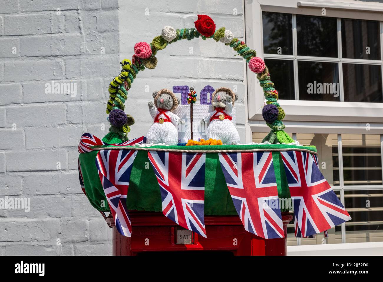 Crocheted mice on a postbox celebrate the Platinum Jubilee of Queen Elizabeth II. Stock Photo