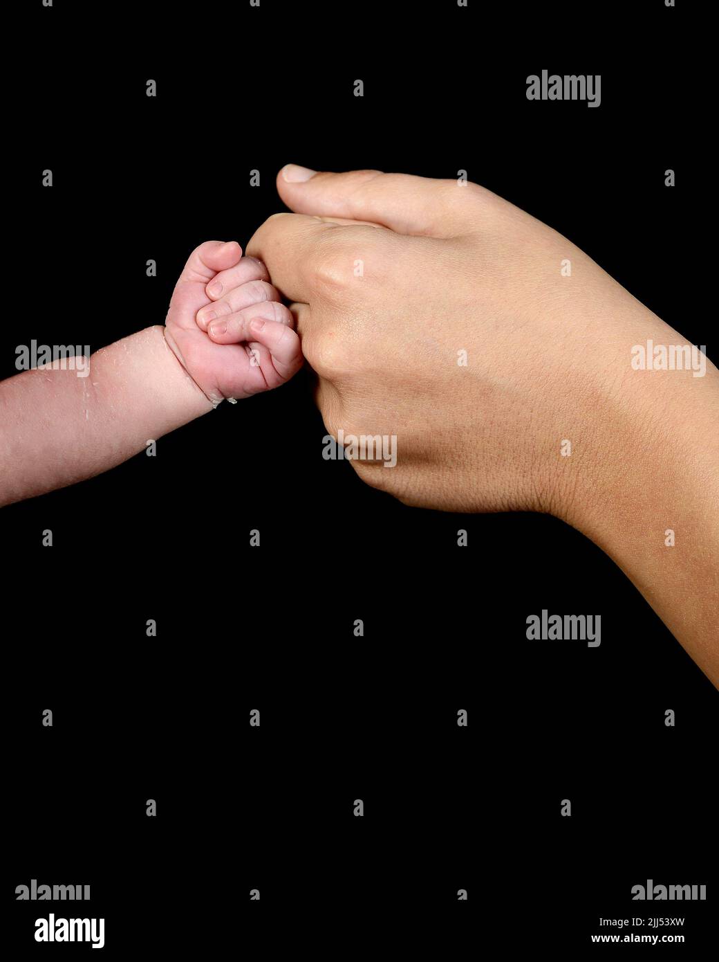The hand of a caucasian newborn with a clenched fist bumps the knuckles