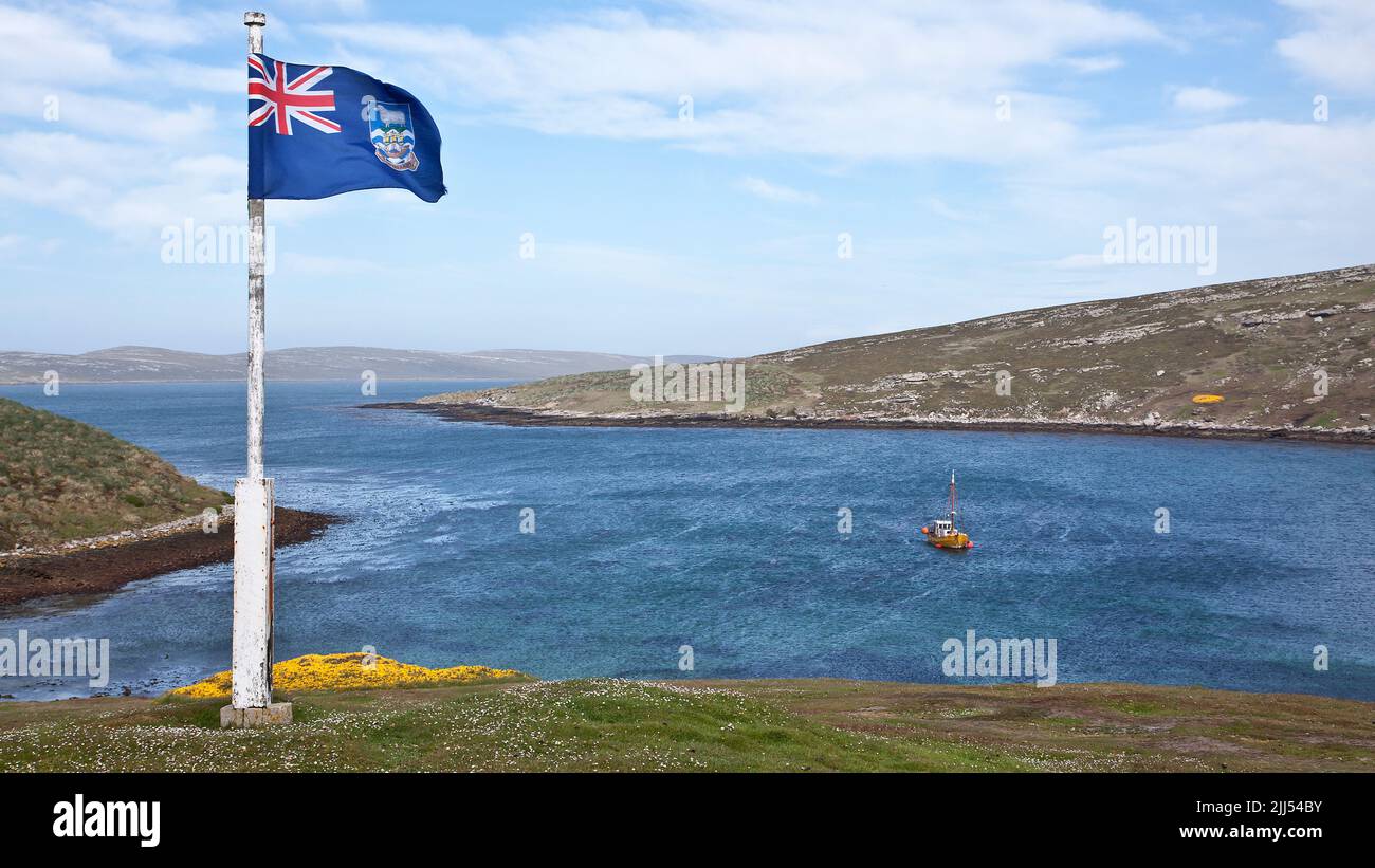 The Falklands flag flies over Settlement Bay, West Point Island, Falkland Islands Stock Photo