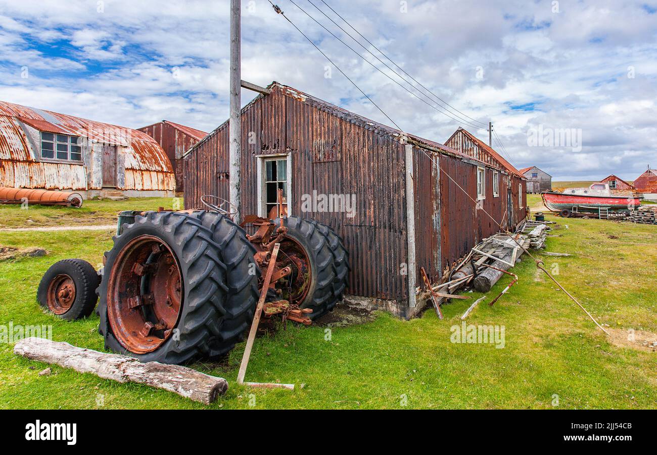 Derelict tractor and weatherworn farm buildings, Pebble Island, Falkland Islands Stock Photo