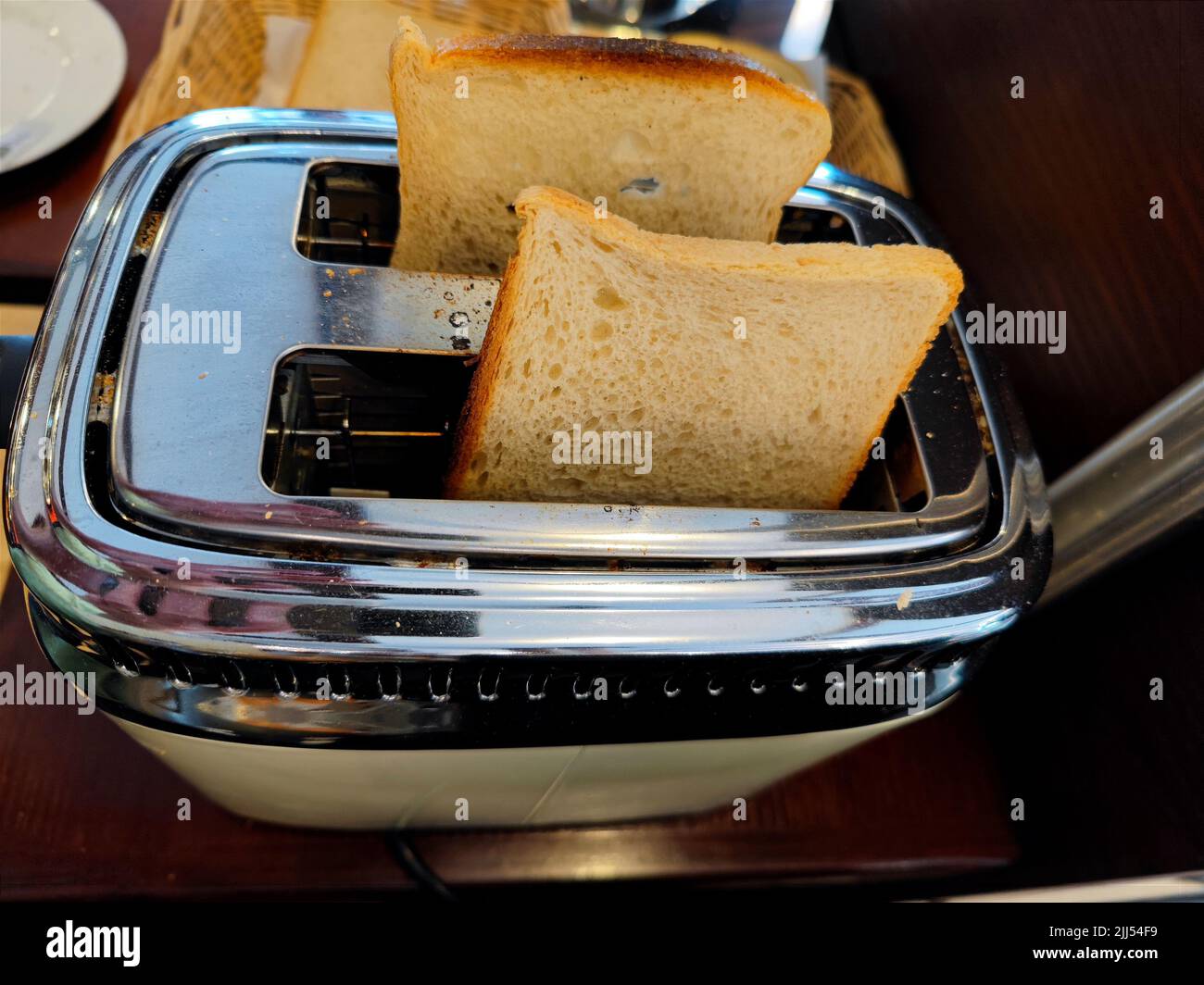 Delicious fresh white bread in a toaster about to be toasted during breakfast Stock Photo