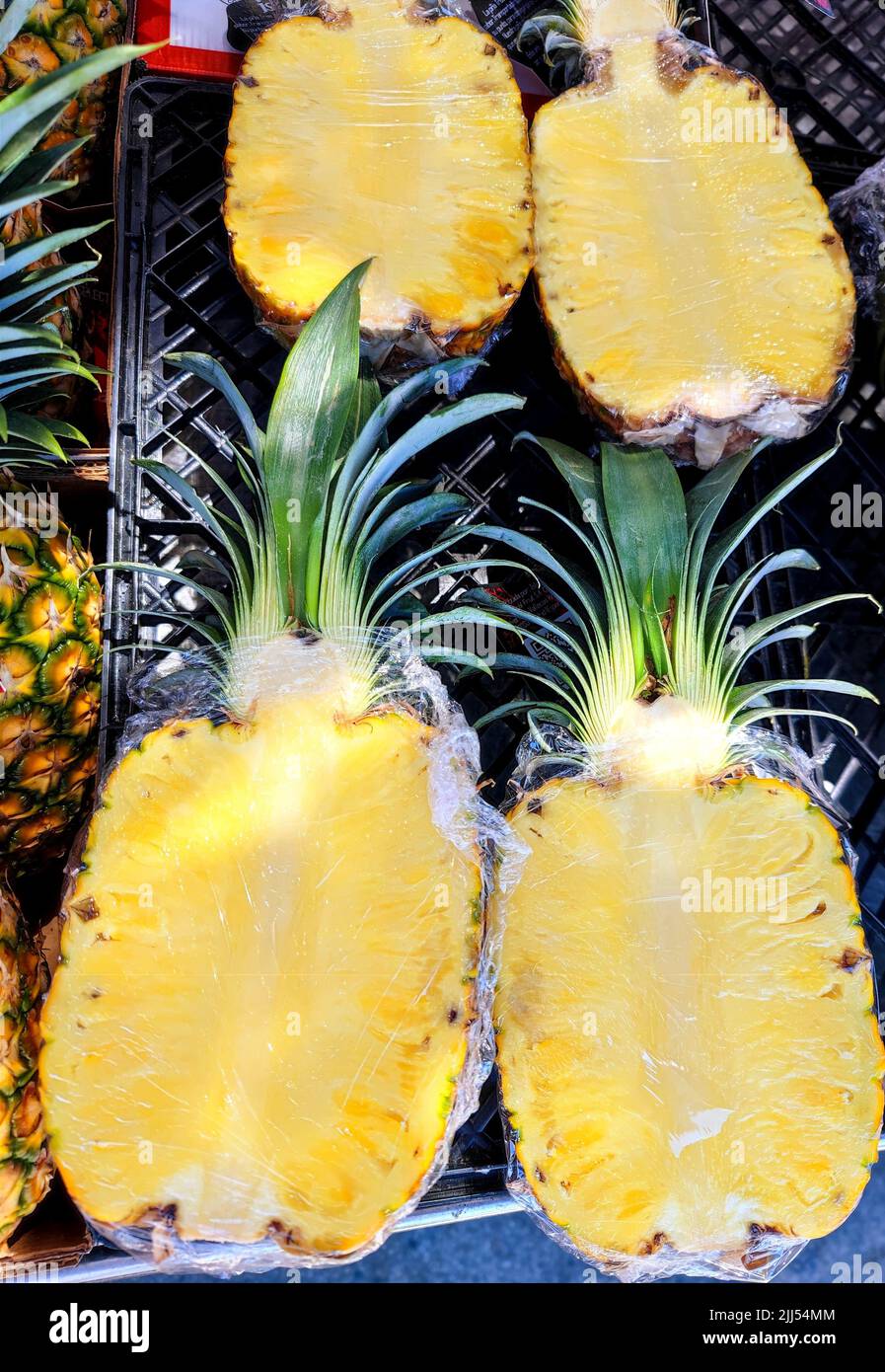 Unmarked beautifully colored sliced pineapple on store shelves in a supermarket Stock Photo