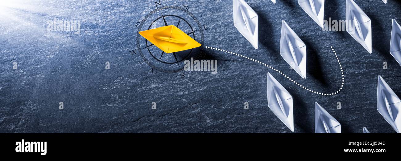 Yellow Paper Boat With Compass Leaving Mainstream And Changing Direction - Entrepreneur/Business Opportunity Stock Photo