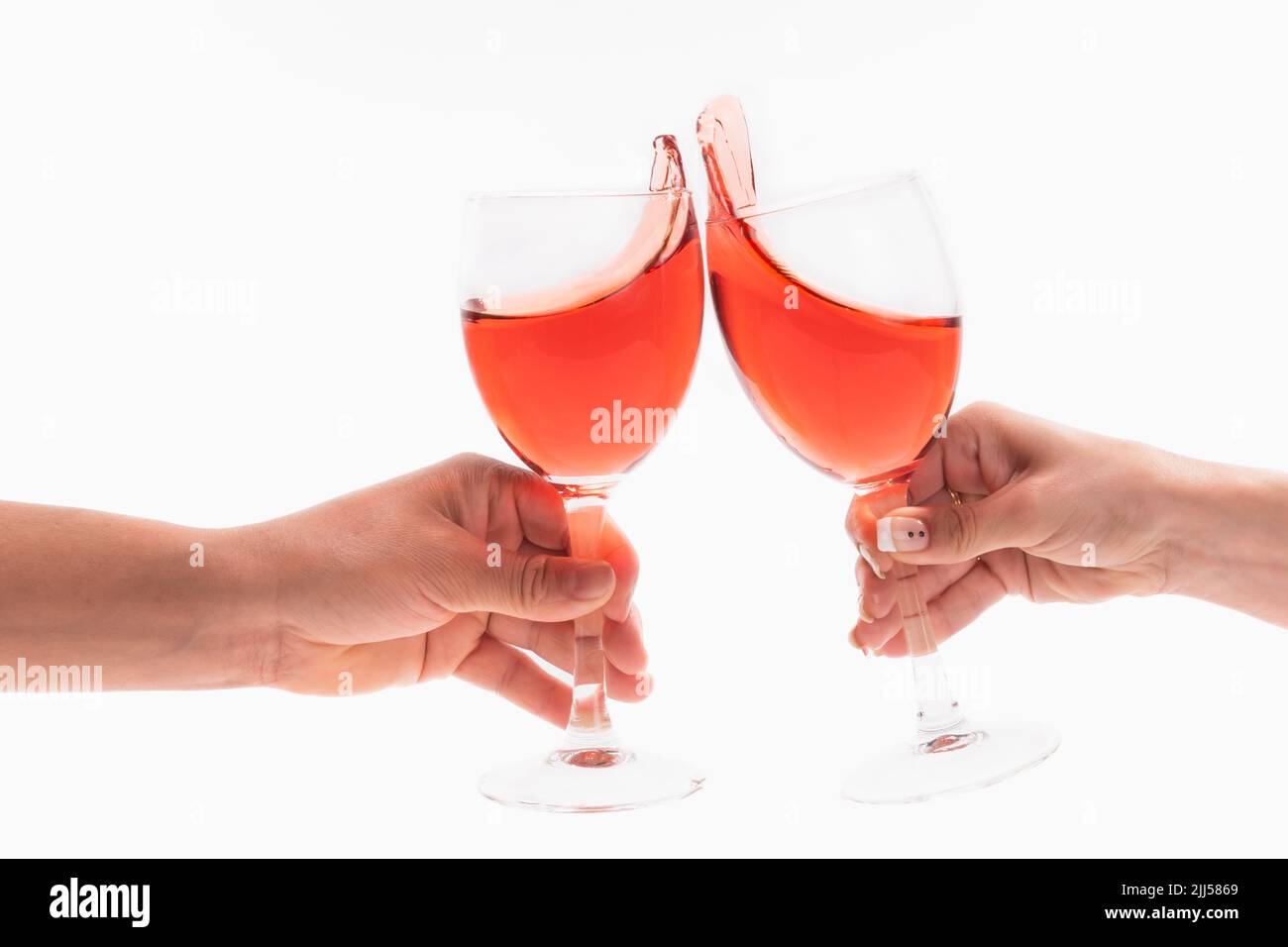 Male and female hands toasting with wine glasses Stock Photo