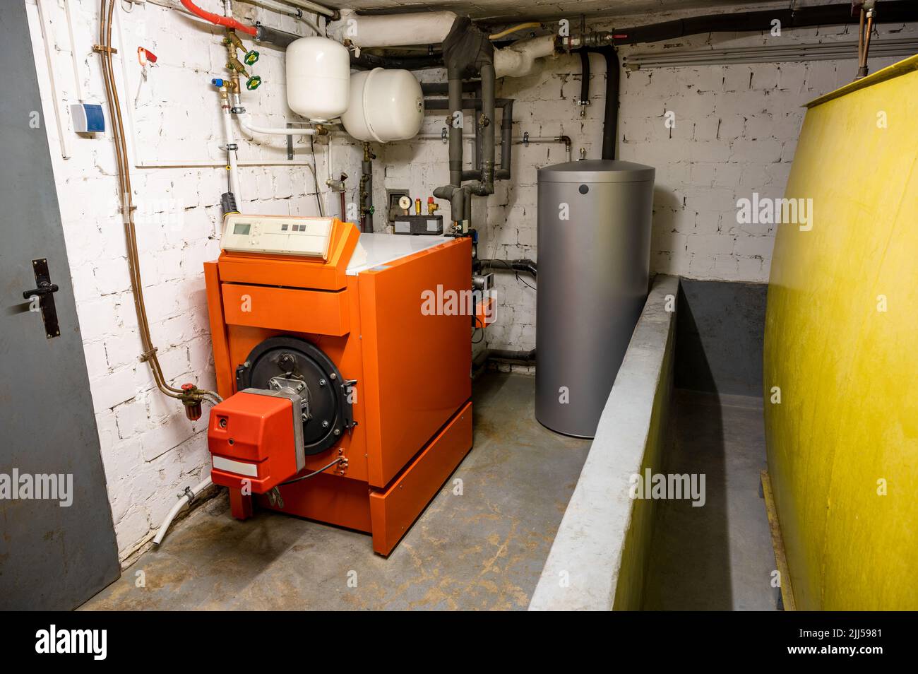 Old oil heating system with oil tank and hot water tank in the basement