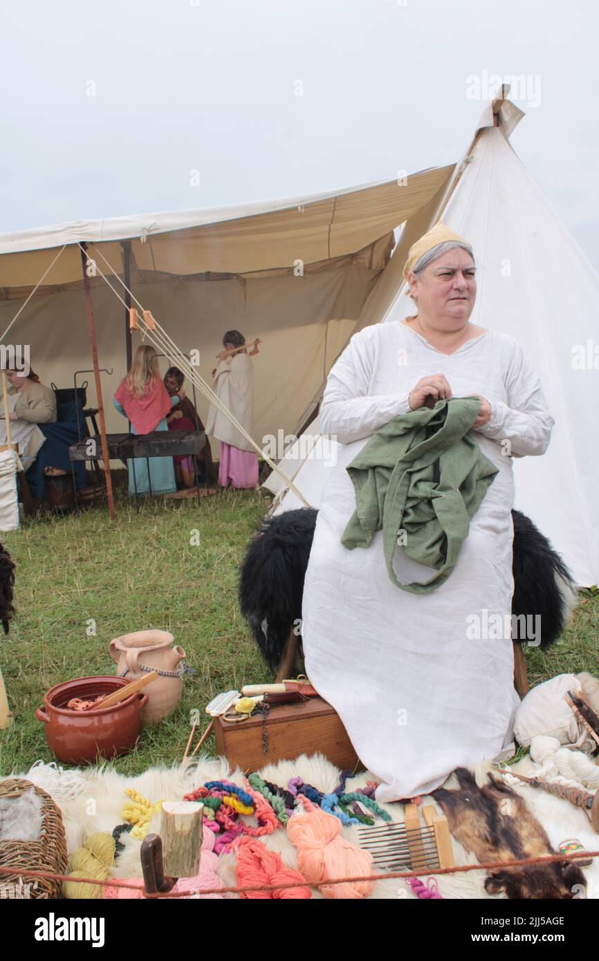 Reenactment of a Viking peasant hand sewing a garment.  Upholland green fayre, Lancashire, England 23-07-2022 Stock Photo