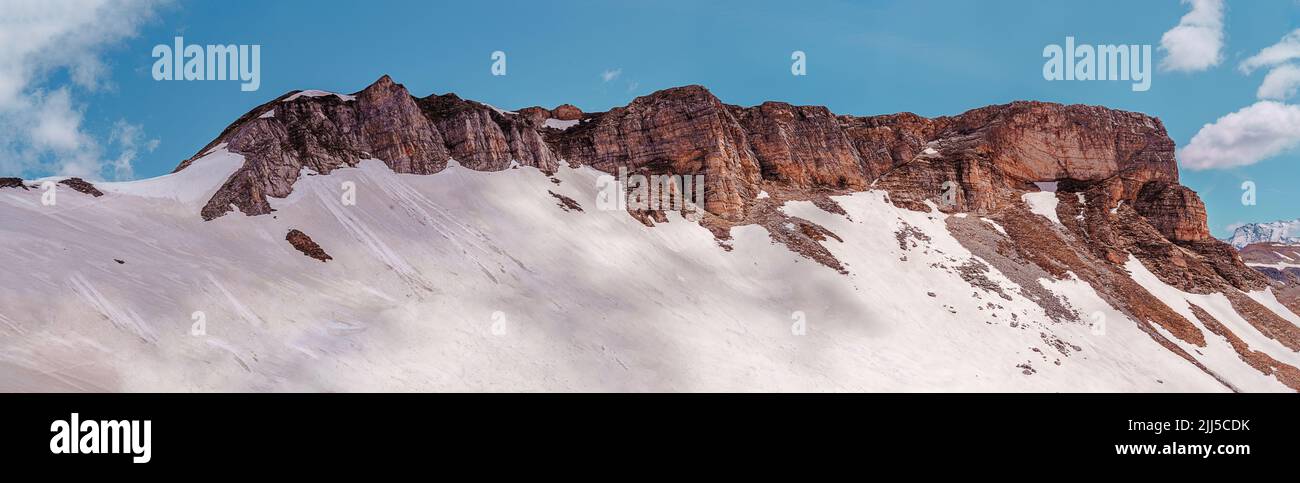 Beautiful mountain peaks with snow in winter. landscape with snowy rocks, and blue sky with clouds. Stock Photo