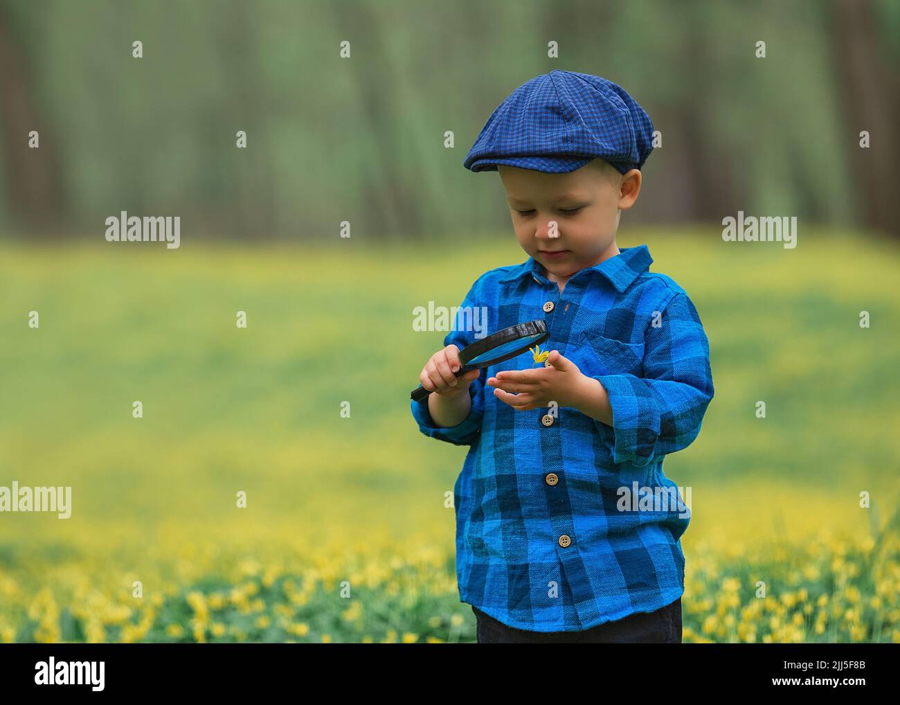 Happy little happy child boy, exploring nature with magnifying glass ...