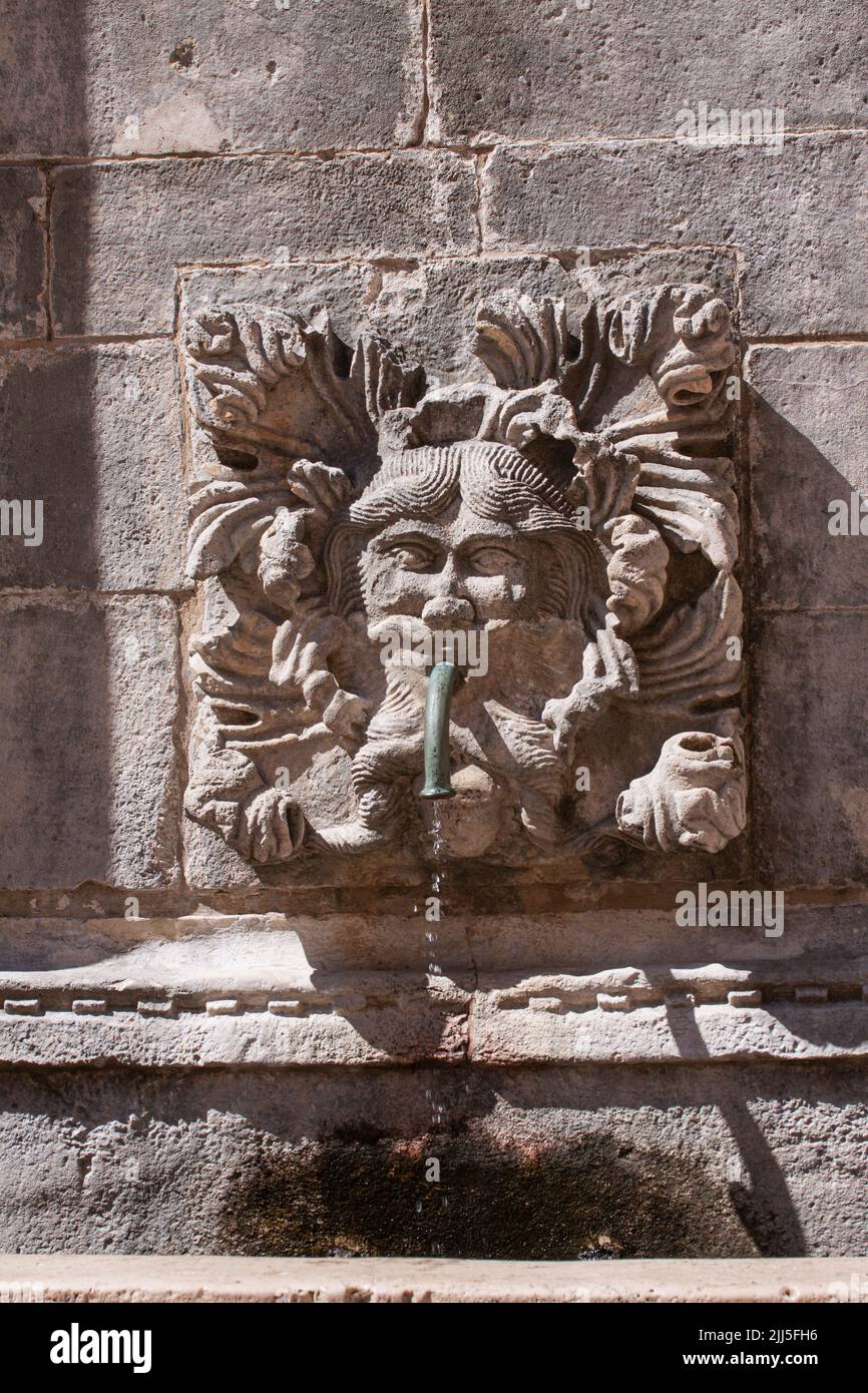 Ancient fountain with drinking water in shape of a bearded male fantasy face in Dubrovnik old city, Croatia. Stock Photo