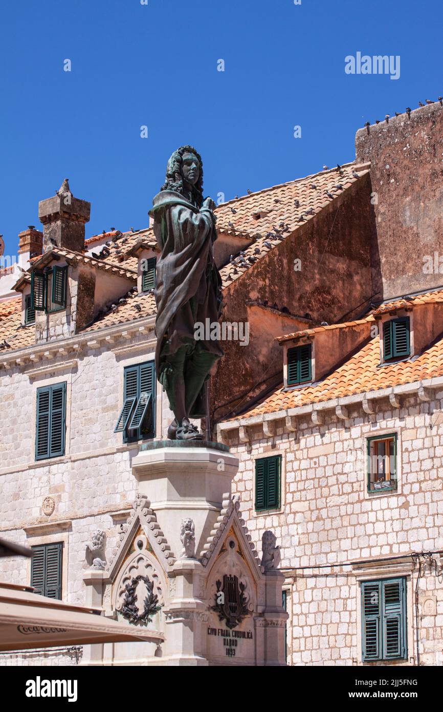 Monument of Poet Ivan Gundulic in Dubrovnik old city. Bronze statue of the famous Dubrovnik poet with blue sky background.. Dubrovnik, Croatia - July Stock Photo