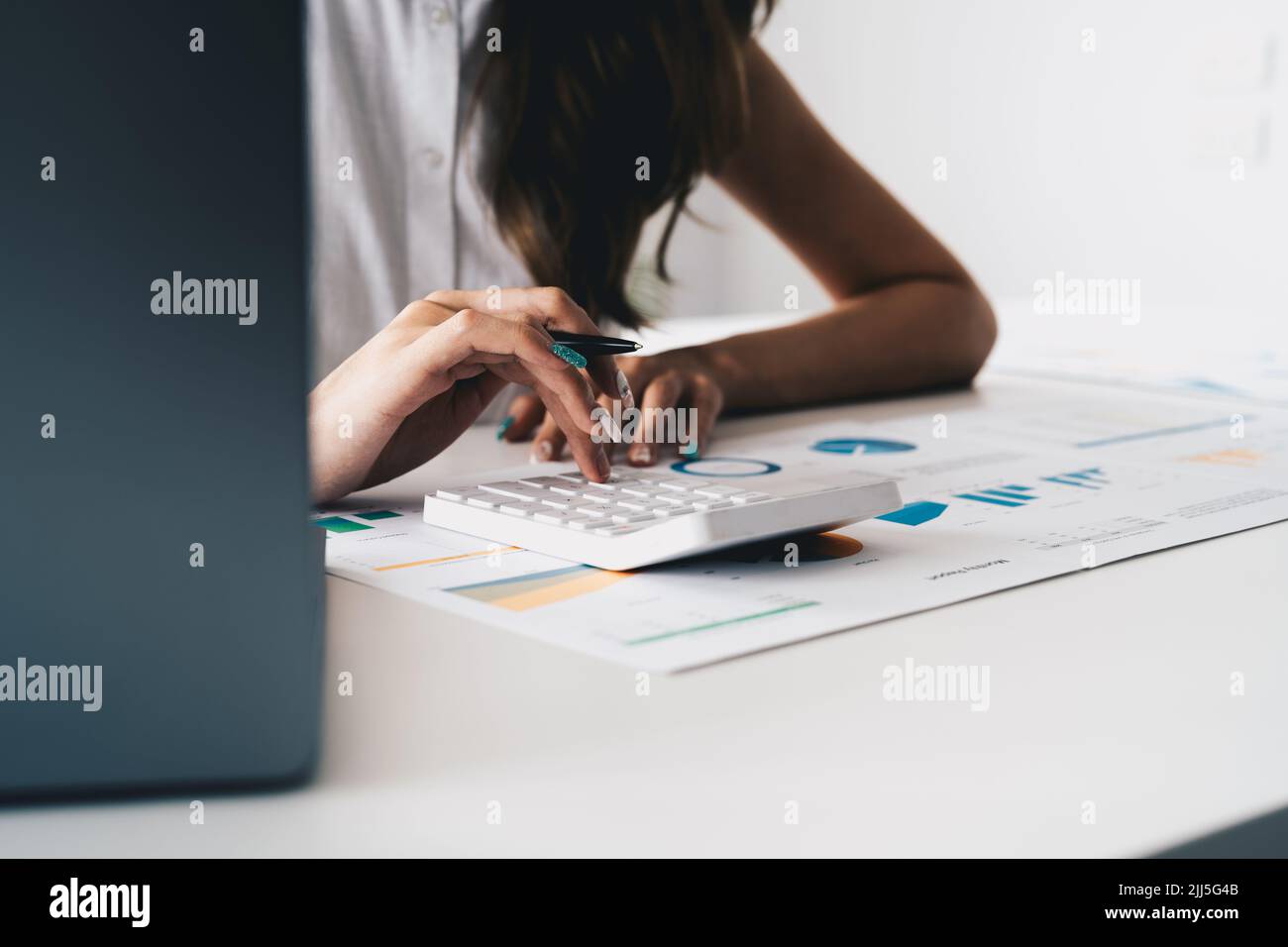 Close up hand of woman entrepreneur using a calculator to calculating financial expense. accounting financial concept. Stock Photo