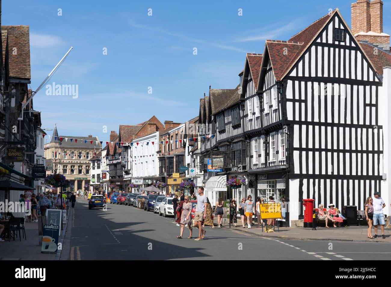 Shoppers and visitors to Stratford upon Avon on the High Street in July, with historic timber framed and plaster infill walled buildings. England Stock Photo
