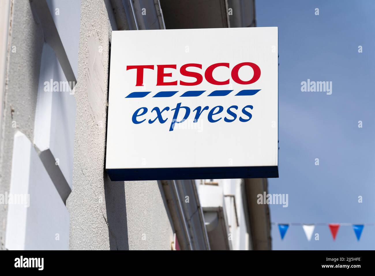 A wall hanging sign with the Tesco Express logo and title on a small convenience store on Bridge Street in Stratford upon Avon, England Stock Photo