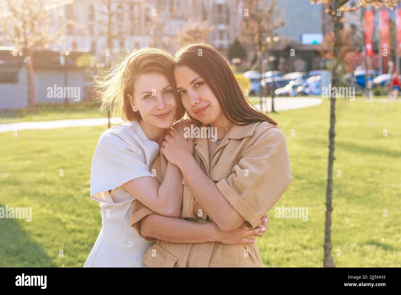 Happy woman with friend standing at park on sunny day Stock Photo