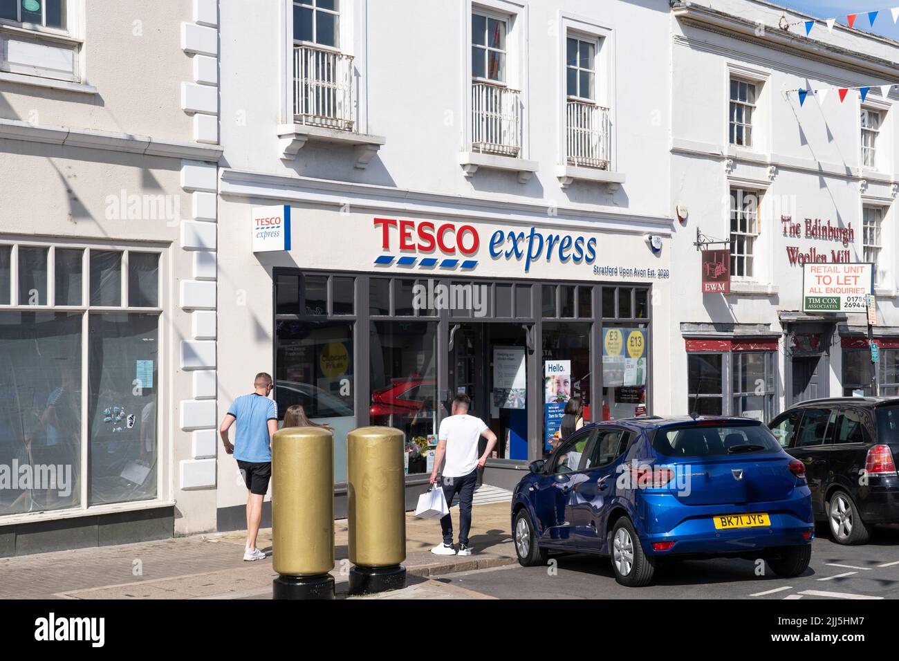 Shoppers entering a Tesco Express on Bridge Street in Stratford upon Avon, England. Concept - cost of living, food shopping, rising inflation Stock Photo