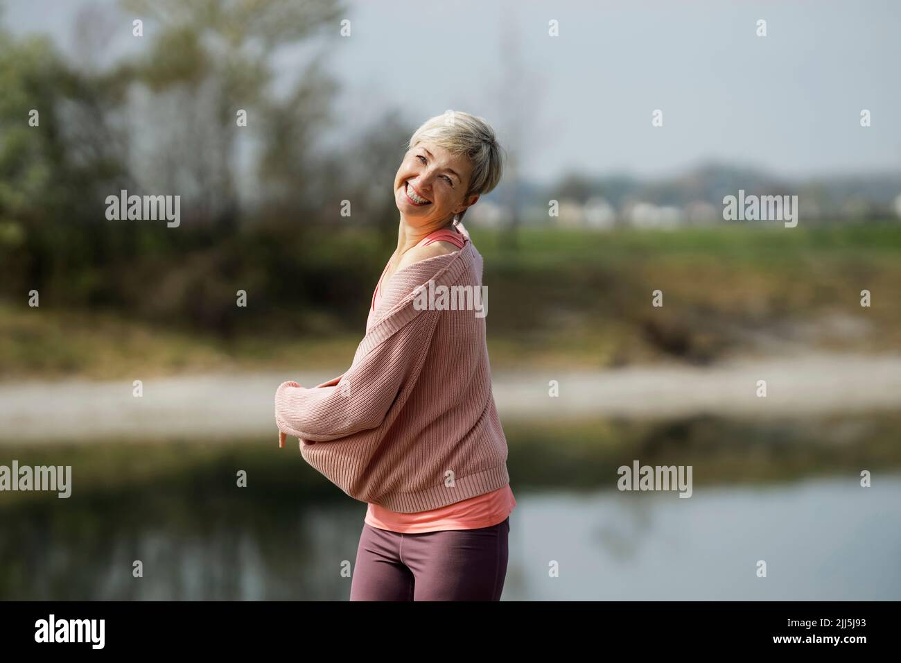 Cheerful mature woman with short hair enjoying sunny day Stock Photo ...