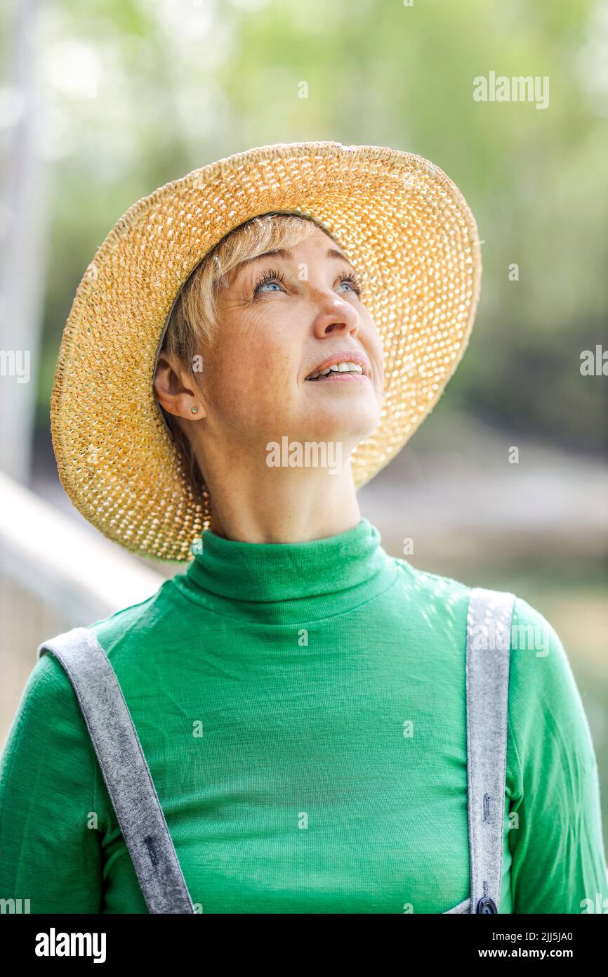 Mature woman wearing hat looking up Stock Photo