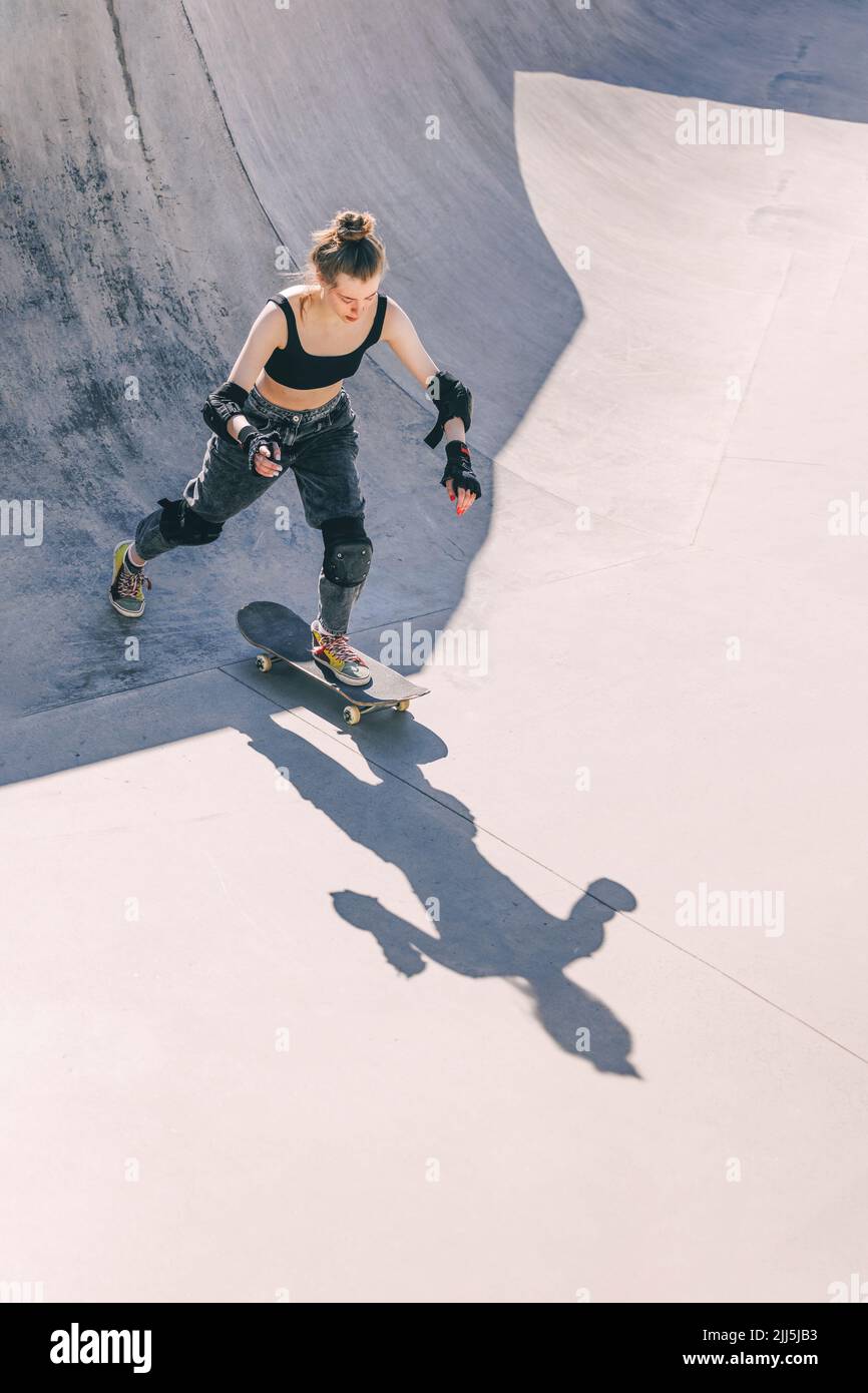 Teenage girl skateboarding at skateboard park Stock Photo