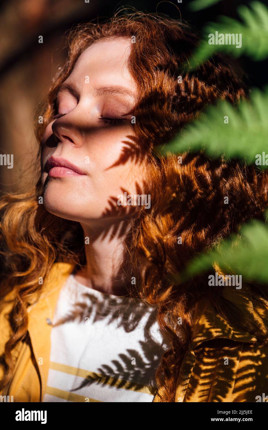 Young woman enjoying sunlight with eyes closed Stock Photo
