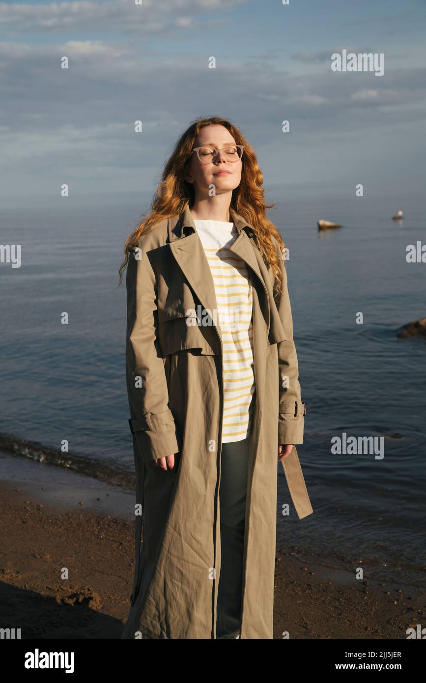 Young woman enjoying sunlight at beach Stock Photo