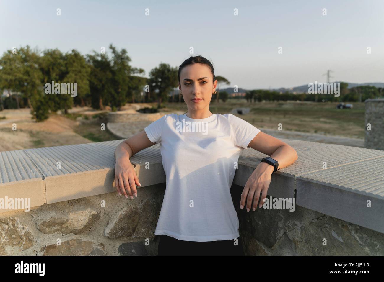 Young woman standing in front of wall Stock Photo - Alamy
