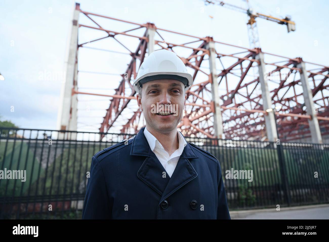 Smiling architect wearing hardhat at construction industry Stock Photo
