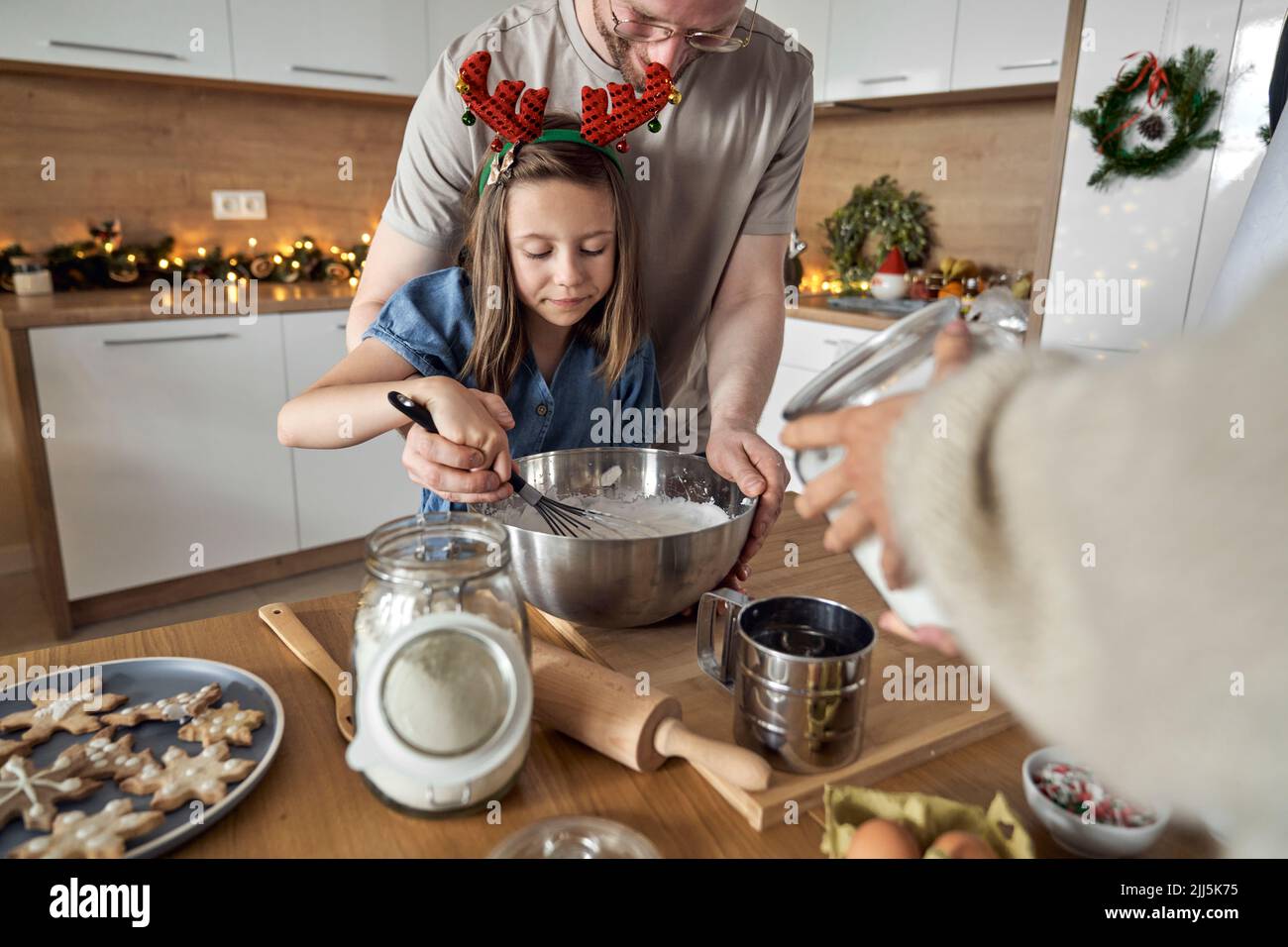 Smiling man with daughter mixing cookie dough in kitchen Stock Photo