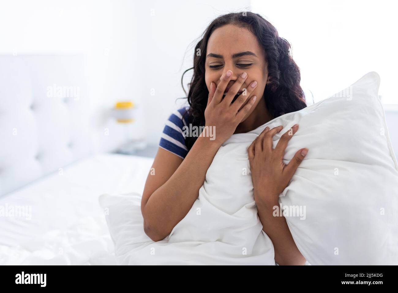 Young Woman Sitting And Yawning On Bed At Home Stock Photo Alamy