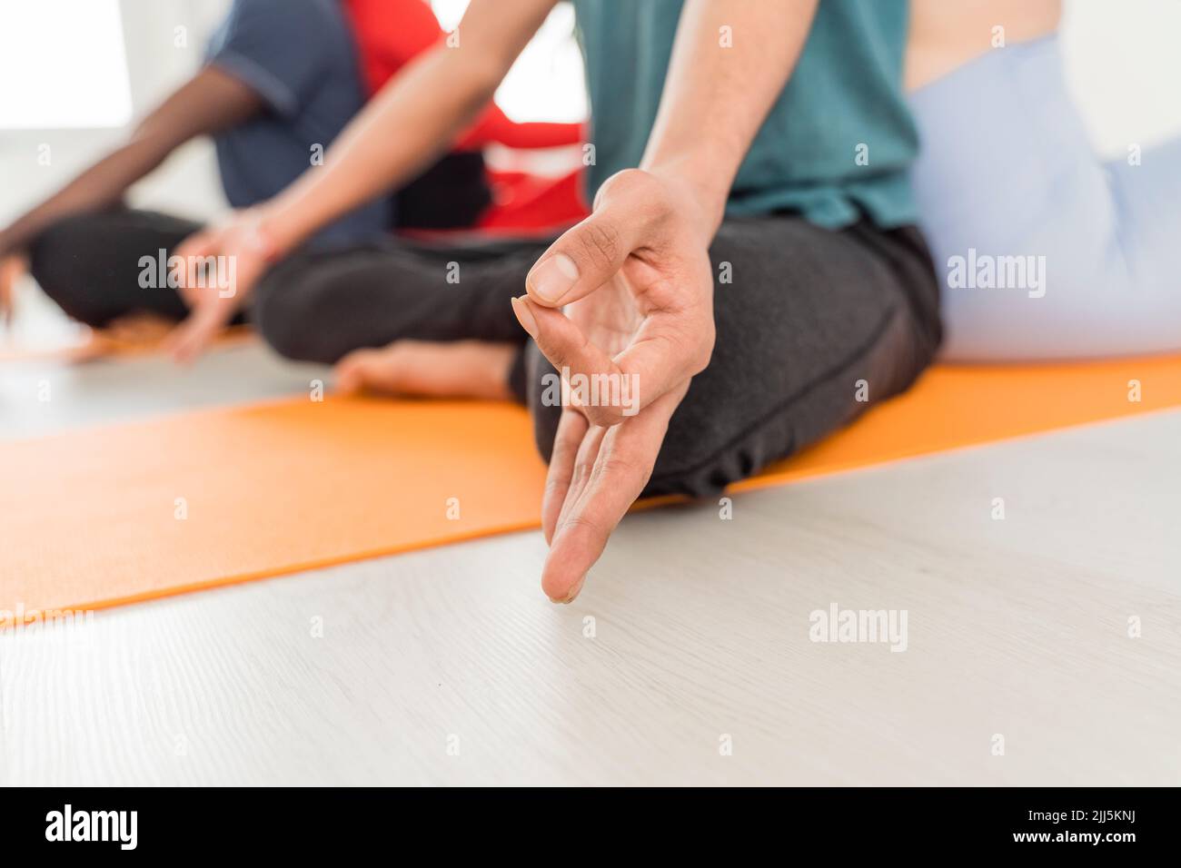 Hand of man meditating with friends at yoga studio Stock Photo