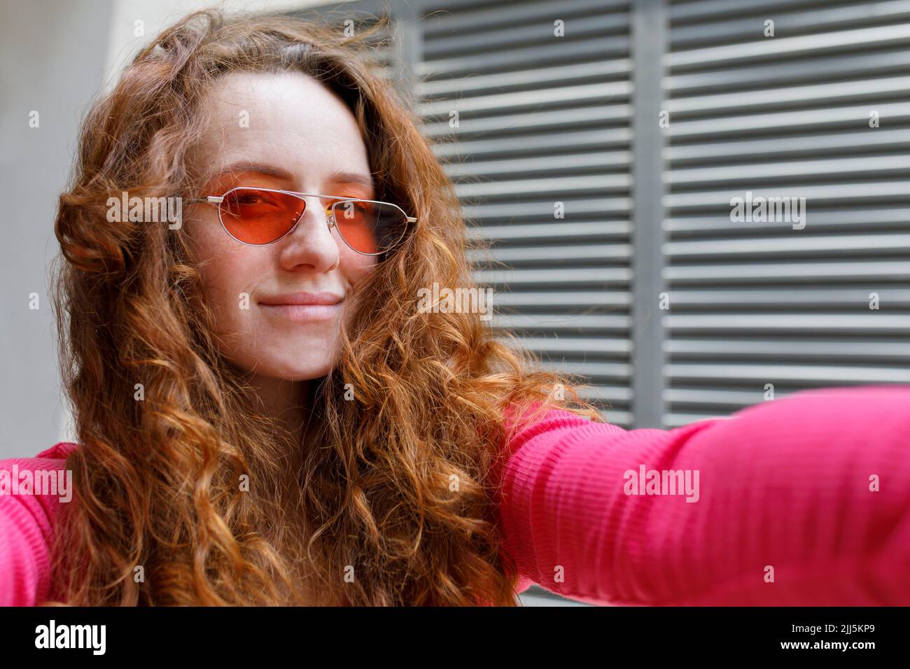 Smiling redhead woman with sunglasses taking selfie Stock Photo - Alamy
