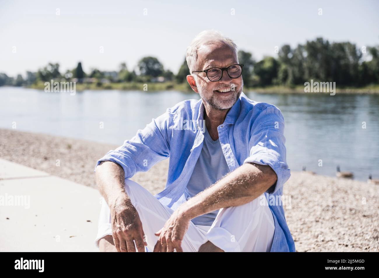 Happy senior man at riverbank Stock Photo Alamy