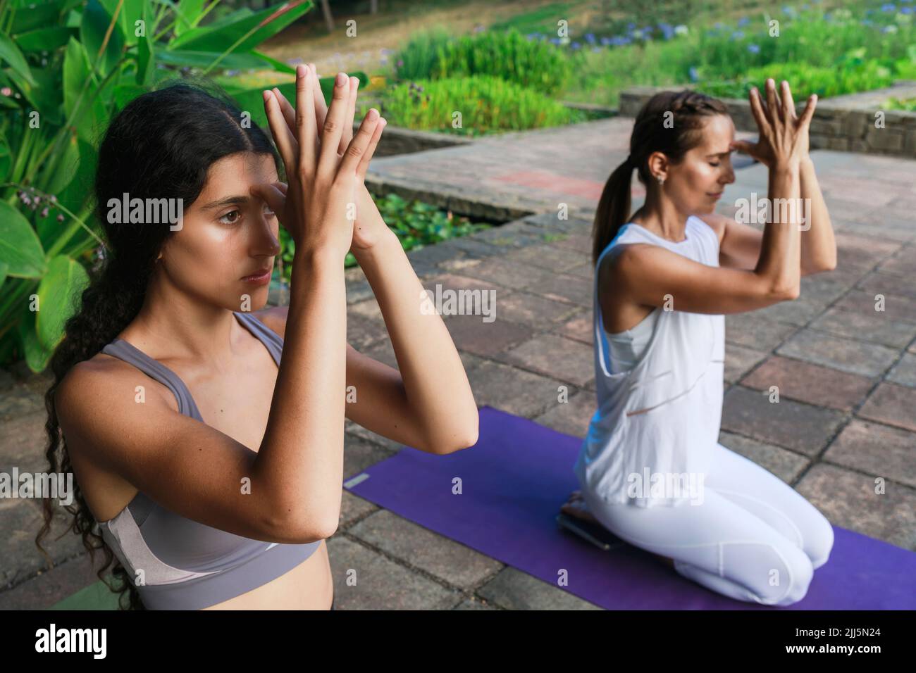 Teenage girl exercising with yoga instructor at park Stock Photo - Alamy