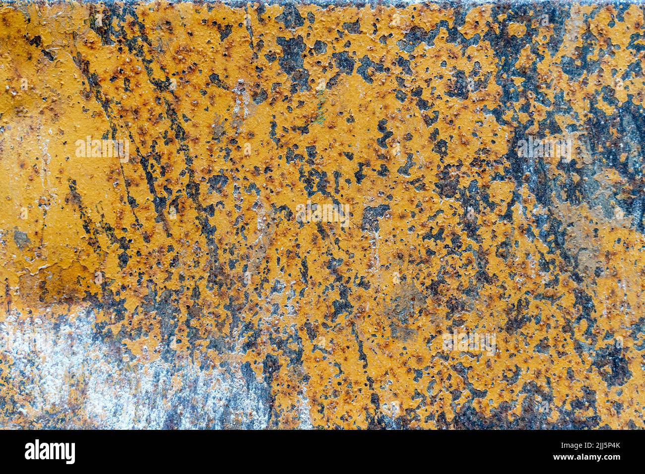 Grunge rusty metal texture background with patches of old yellow paint