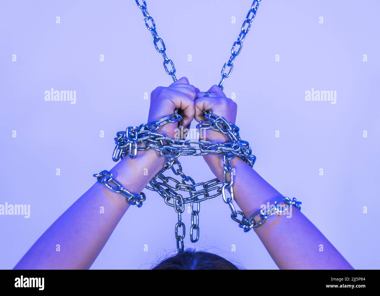 Hands of woman tied with chain Stock Photo