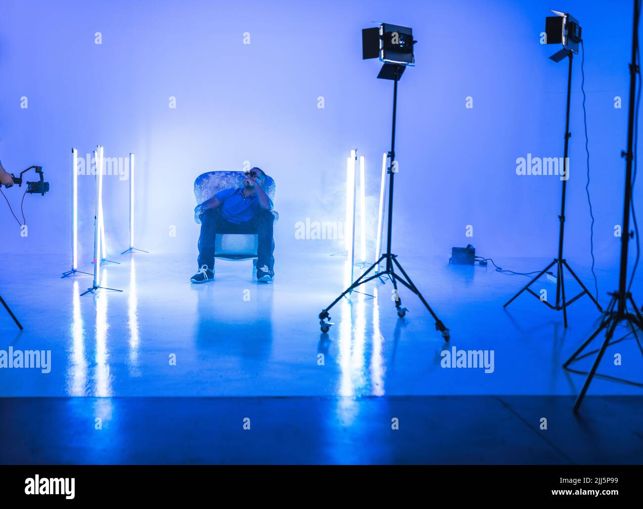 Singer sitting on chair filming at studio Stock Photo Alamy