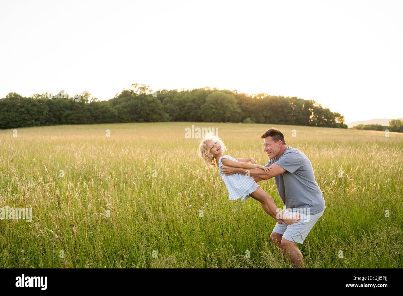 Father and daughter having fun in field Stock Photo