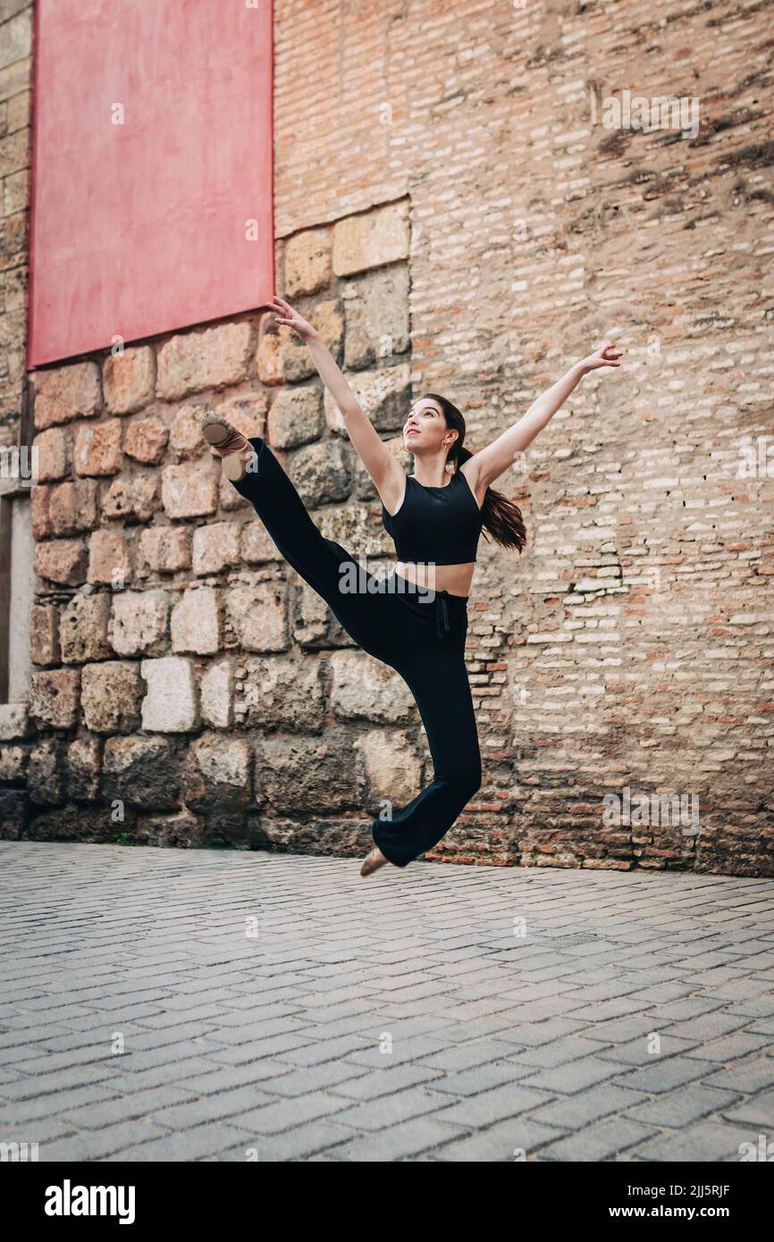 Woman practicing ballet near brick wall Stock Photo