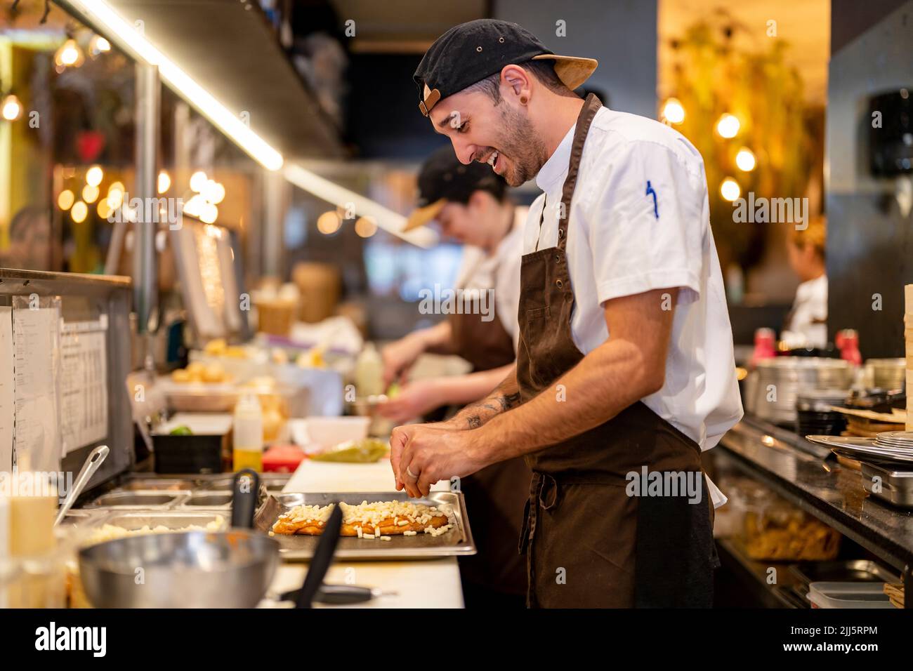 Smiling chef preparing food at restaurant kitchen Stock Photo