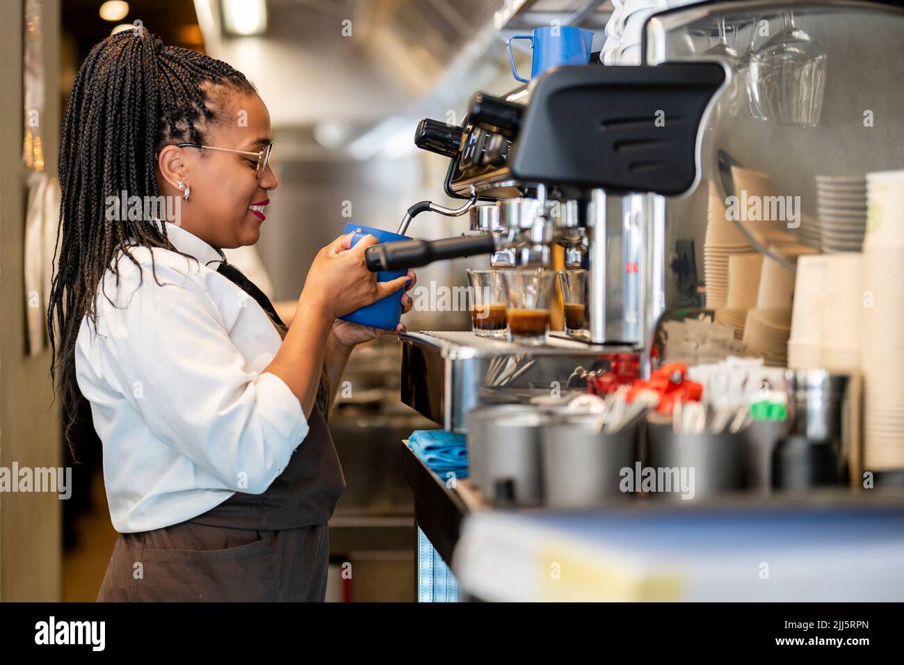 Smiling barista making coffee at restaurant kitchen Stock Photo