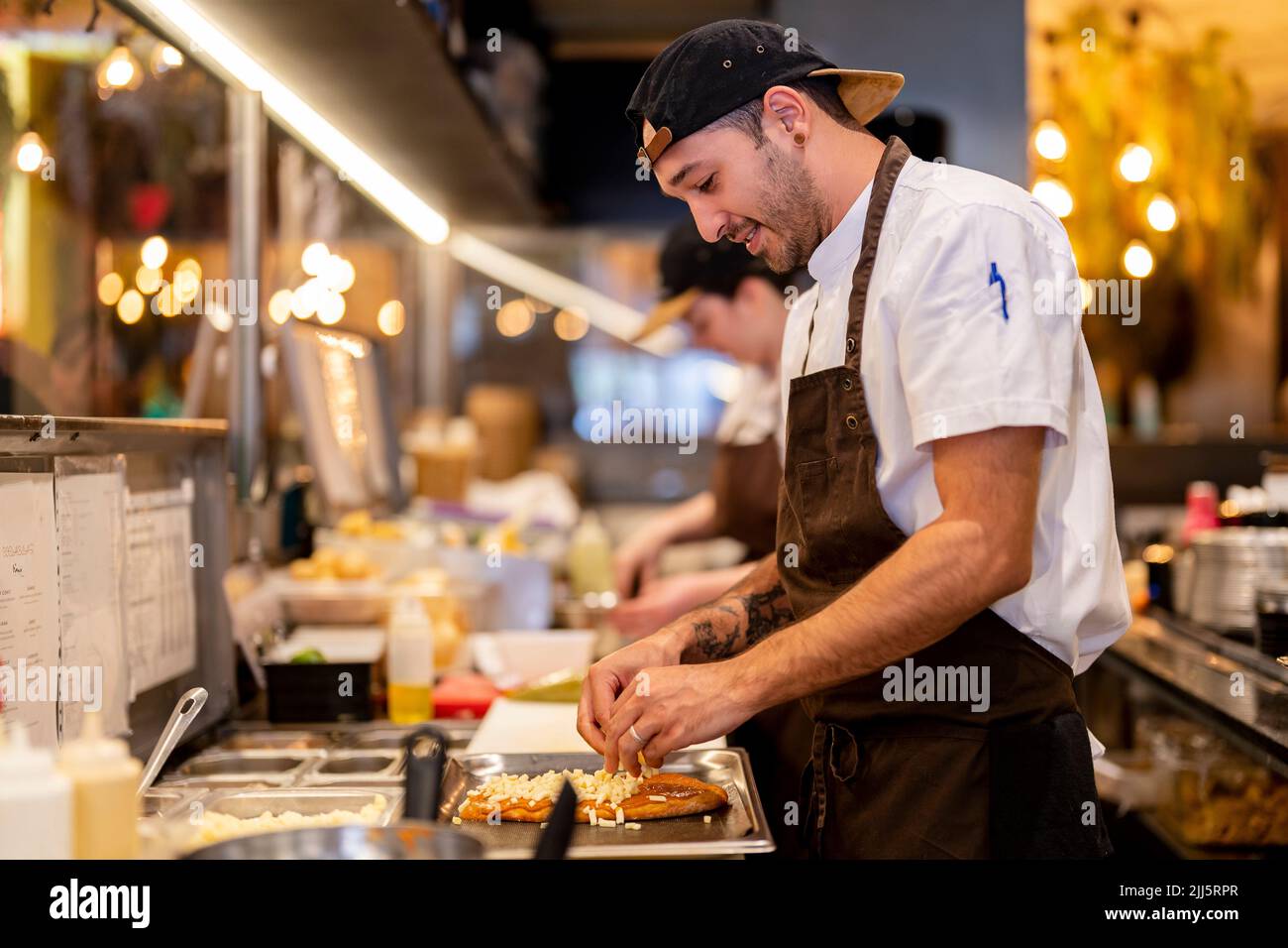 Smiling man preparing food at restaurant kitchen Stock Photo