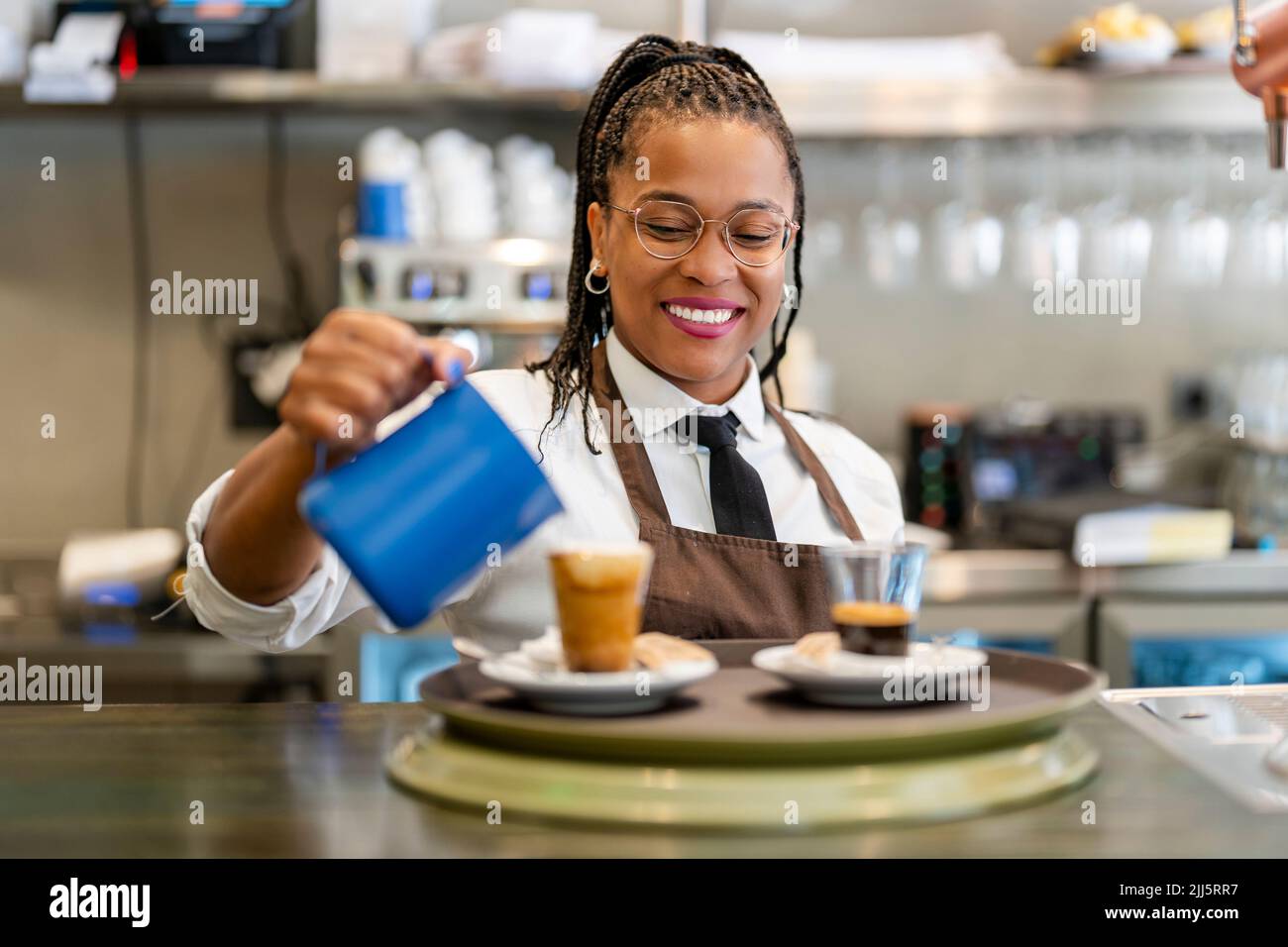 Happy barista pouring coffee in cup Stock Photo