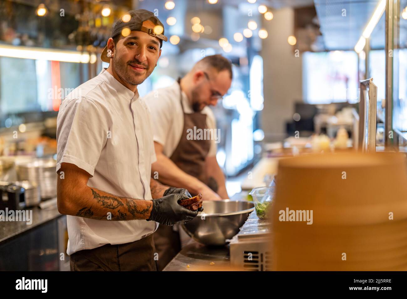 Smiling chef preparing with food in kitchen of restaurant Stock Photo