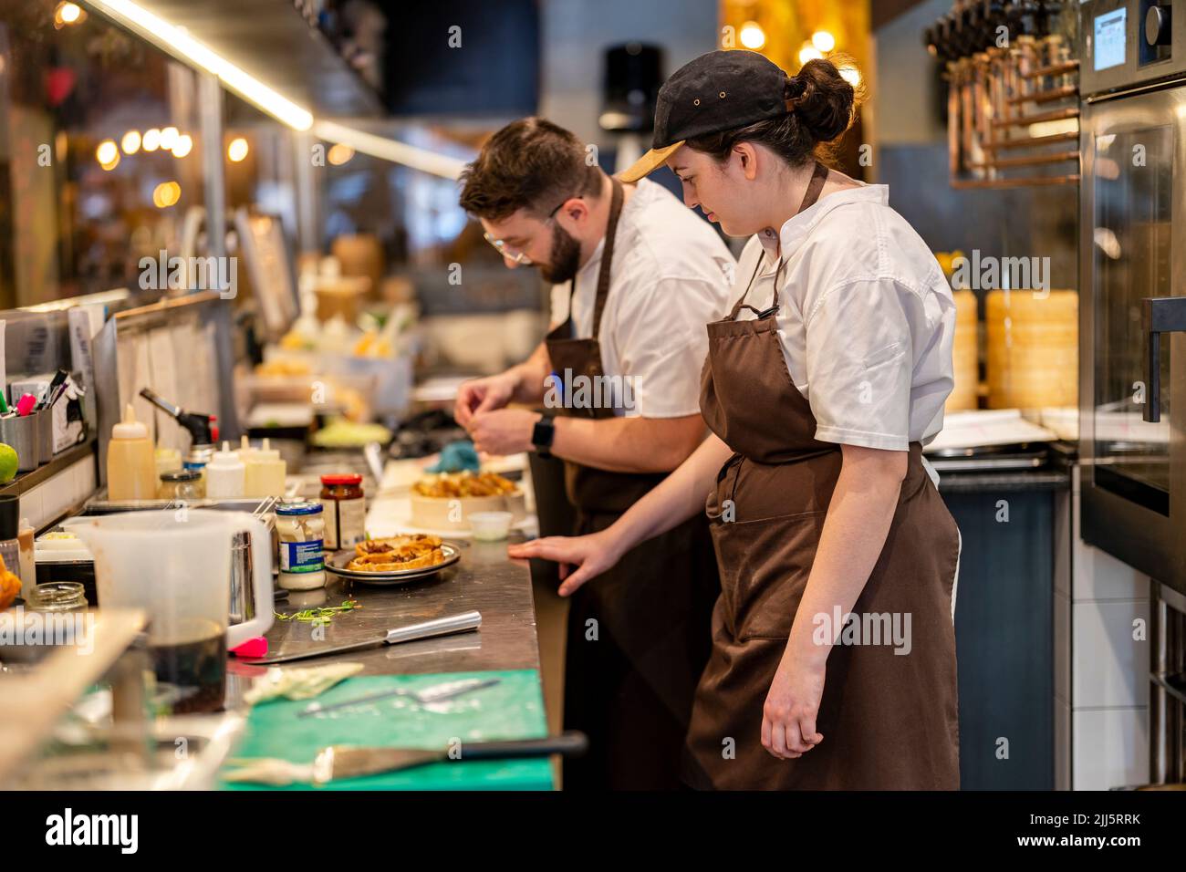 Chefs preparing food standing at restaurant kitchen Stock Photo