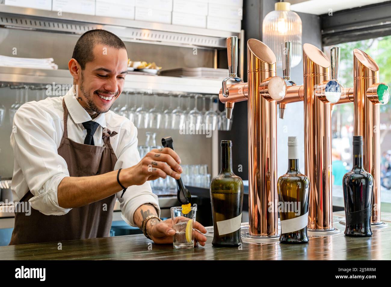 Smiling bartender making cocktail at bar counter Stock Photo
