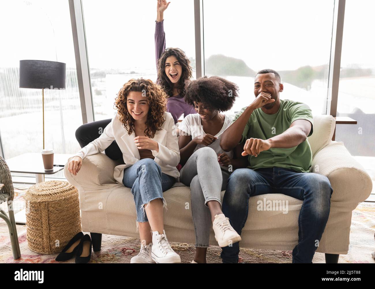 Cheerful friends having fun on sofa Stock Photo