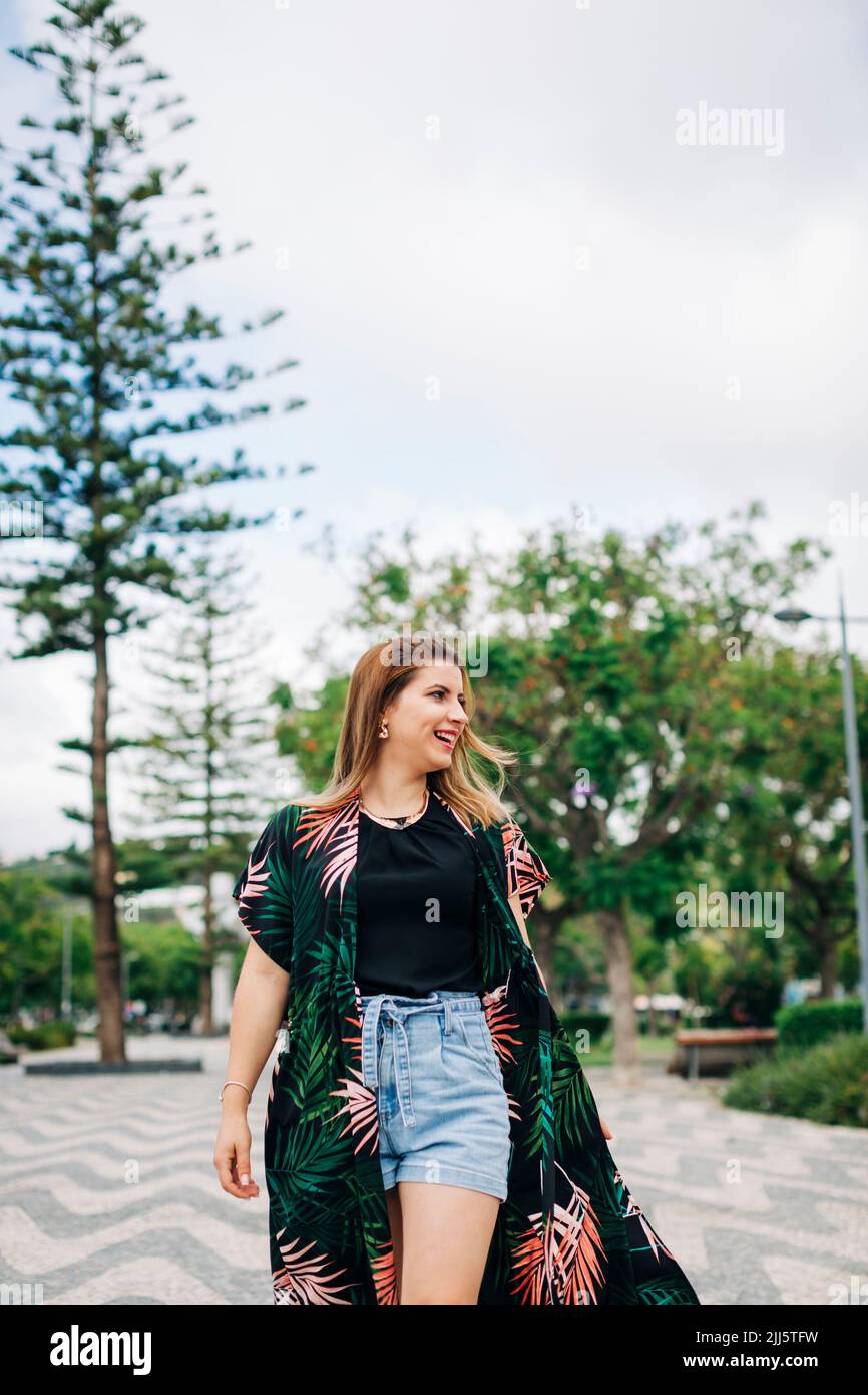 Happy young woman walking in park Stock Photo - Alamy