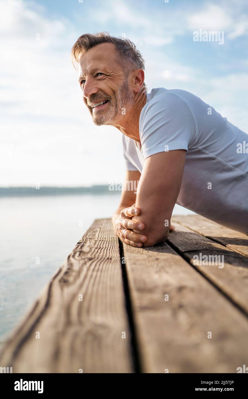 Happy mature man leaning on pier at lake Stock Photo Alamy Happy mature man leaning on pier at lake Stock Photo Alamy