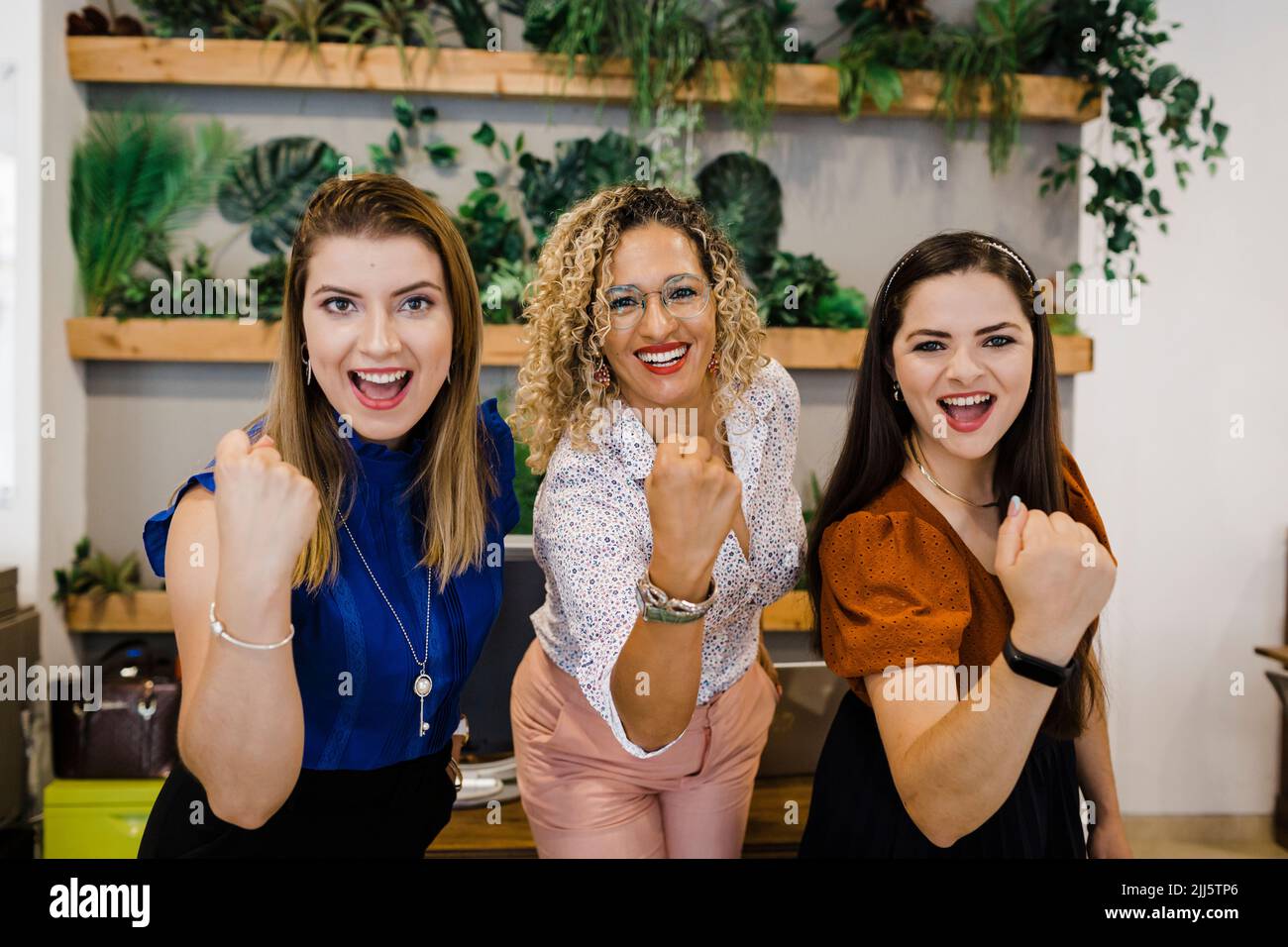 Excited business colleagues clenching fists in office Stock Photo